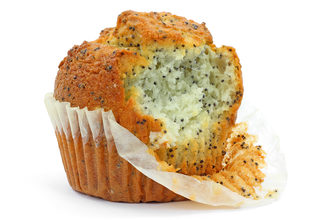 A freshly baked poppy seed muffin in paper cooking cup that has been bitten on a white background.