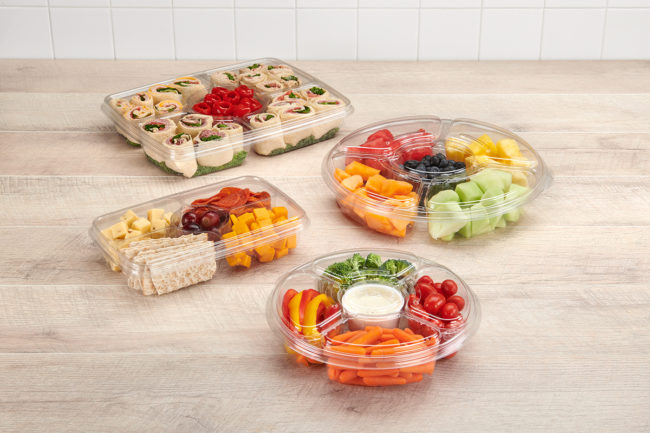 plastic party trays with fruit, vegetables, and wraps