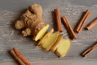 cinnamon sticks and ginger root on a wooden surface