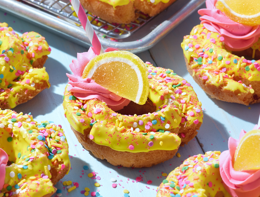 A group of donuts with yellow frosting and lemon slice

Description automatically generated